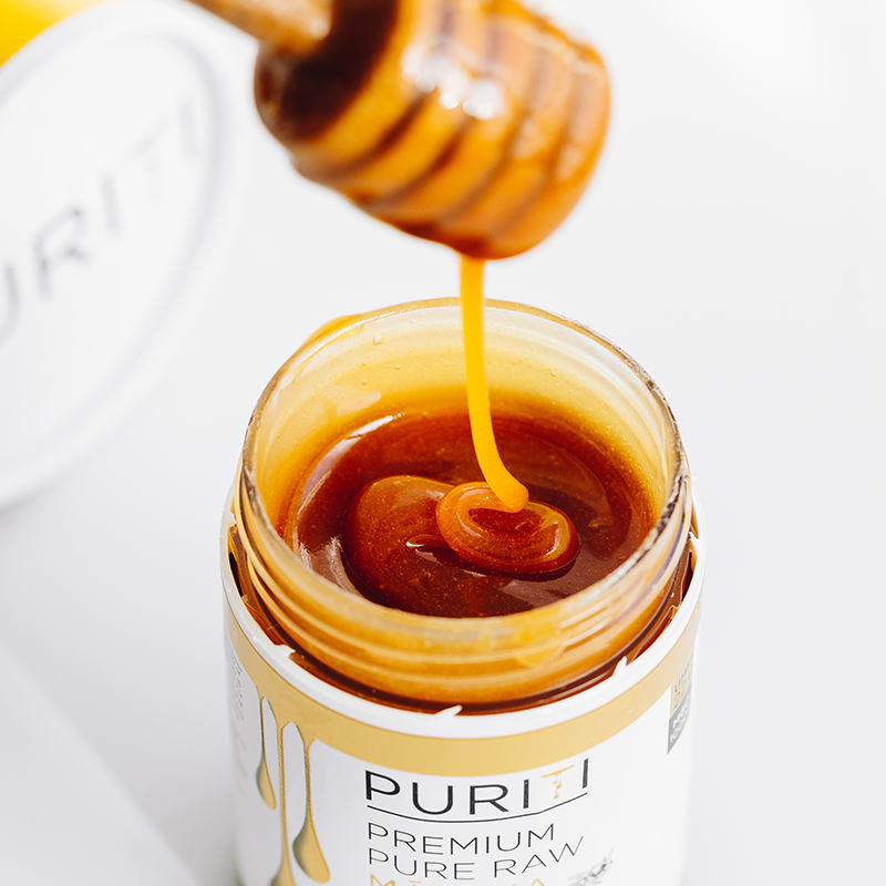 Puriti Manuka Honey dripping into a jar